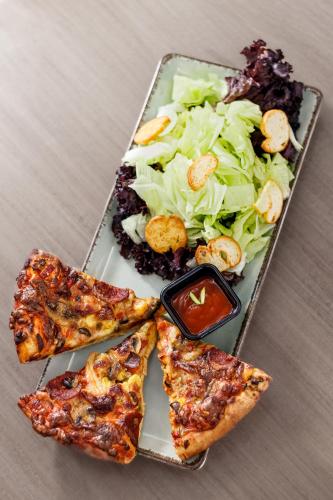 a plate of food with a salad and pizza at Taksim REXXEE Istanbul Istiklal Hotel in Istanbul