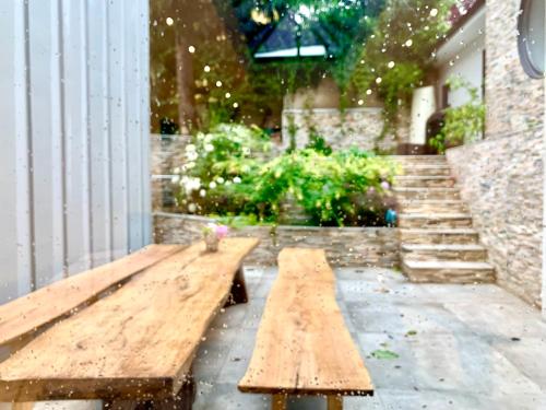 eine Holzbank vor einem Gebäude mit Treppe in der Unterkunft Maison de Verdure proche de Paris in Bagneux