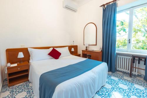 a bedroom with a large bed and a window at Hotel Villa Sarah in Capri