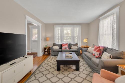 a living room with a couch and a flat screen tv at Charming New England Home in West Hartford Center in West Hartford