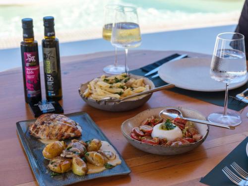 a table with two plates of food and glasses of wine at Axel Beach Mykonos - Adults Only in Mýkonos City