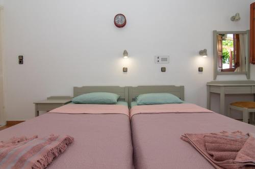 a bedroom with two beds with pink and blue sheets at Giannakos Apartments in Ydroússa