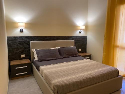 a bedroom with a bed with two lights on the wall at Concas Apartaments in Portoscuso