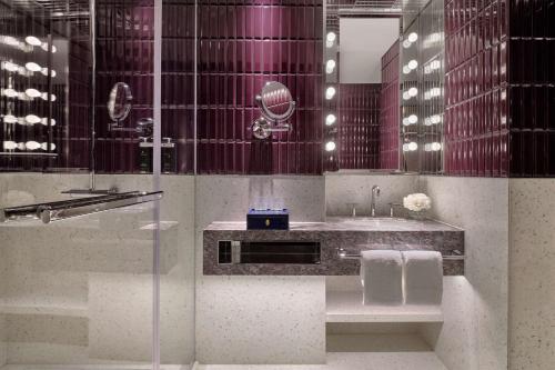 a bathroom with a sink and a glass shower at Hyatt Centric Zhongshan Park Shanghai in Shanghai