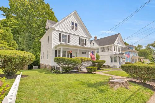 a white house with american flags in the yard at Charming New England Home in West Hartford Center in West Hartford