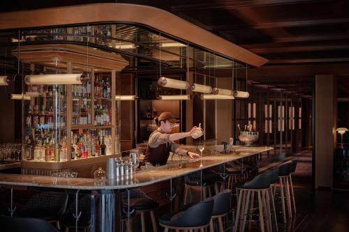 a bartender making a drink at a bar at Hyatt Centric Zhongshan Park Shanghai in Shanghai
