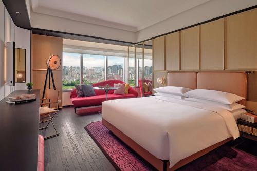 a bedroom with a large bed and a living room at Hyatt Centric Zhongshan Park Shanghai in Shanghai