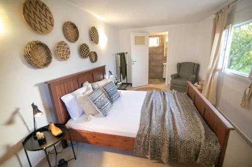 a bedroom with a bed and a chair and a window at Kalamos sea view villa Beach walking distance in Áyioi Apóstoloi