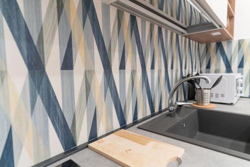 a kitchen with a sink and geometric wallpaper at Toto e Peppino Luxury Rooms in Naples