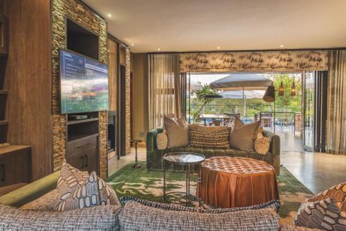 a living room with couches and a flat screen tv at Elephant Point in Skukuza
