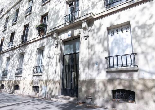 - un bâtiment blanc avec une porte et un balcon dans l'établissement Le refuge du Robespierre à Saint-Denis, à Saint-Denis