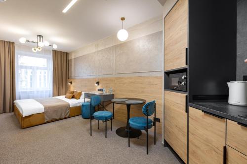 a hotel room with a bed and a table and chairs at Jam Apartments Miskevycha in Lviv