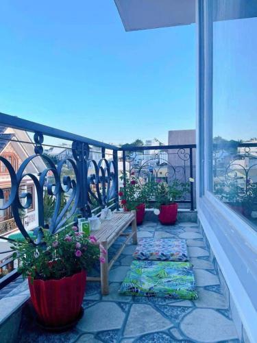 a balcony with a bench and potted plants on it at Nhà của Nâu - Homestay Đà Lạt in Da Thanh