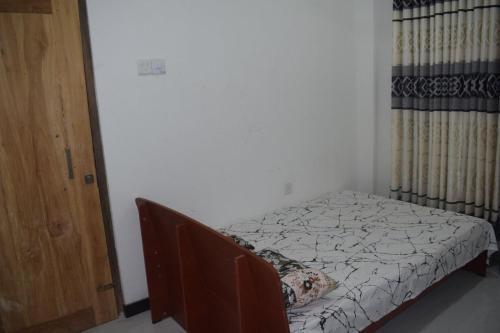 un petit lit dans une chambre avec un cadre de lit dans l'établissement Shenu Resort, à Mawella