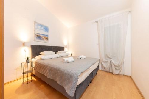 a bedroom with a bed with two towels on it at House Runjic with pool, large garden and playground in Prgomet