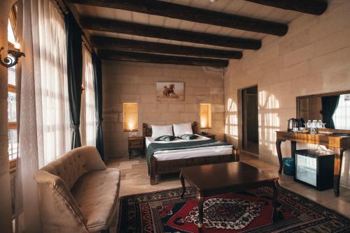a bedroom with a bed and a couch and a table at Lagania In Cave in Urgup