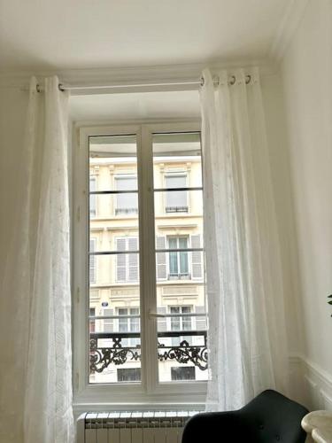 une fenêtre avec vue sur un bâtiment dans l'établissement Studio Châtivesle, à Reims