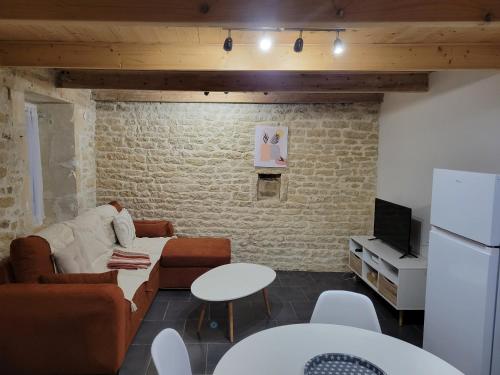 un salon avec un canapé et une télévision dans l'établissement Maison de ville, à Niort