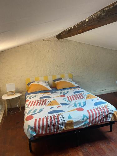 un lit avec une couette colorée dans une chambre dans l'établissement Maison de ville, à Niort
