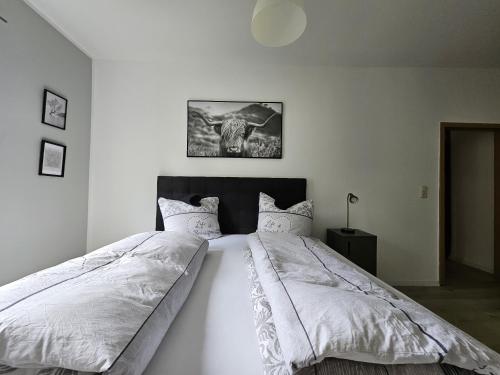 Un dormitorio con una cama grande con sábanas blancas. en Gästehaus Kölnische Straße, en Kassel