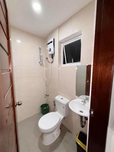 a small bathroom with a toilet and a sink at Kataluma Inn in El Nido