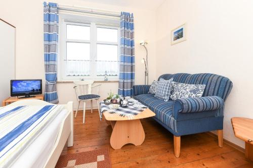 a living room with a blue couch and a table at Ferienwohnung auf dem Ferienhof Janssen in Westerholt