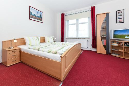 a bedroom with a bed and a television in it at Ferienwohnung auf dem Ferienhof Janssen in Westerholt