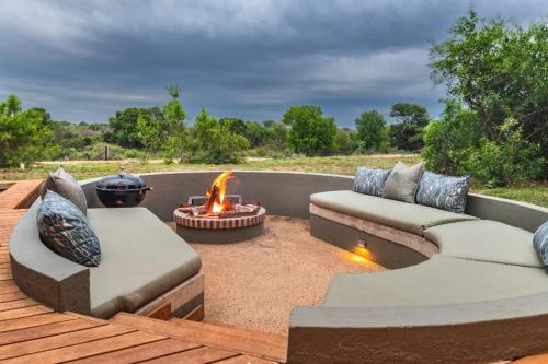 a patio with two couches and a fire pit at Elephant Point in Skukuza