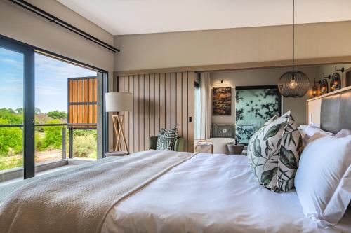 a bedroom with a large bed and a large window at Elephant Point in Skukuza