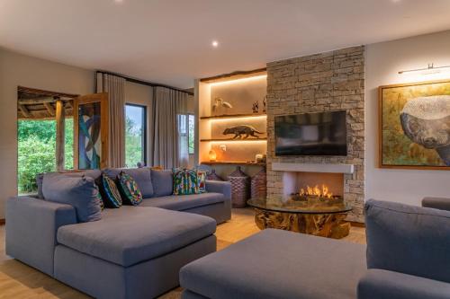 a living room with a couch and a fireplace at Elephant Point in Skukuza