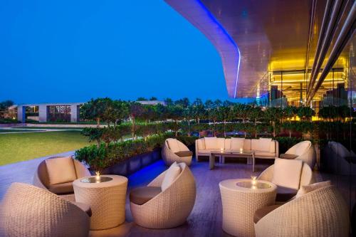 a restaurant with white chairs and tables in a building at Marriott Hotel Al Forsan, Abu Dhabi in Abu Dhabi
