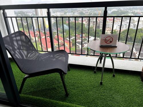a chair and a table with a laptop on a balcony at Horizon Ipoh 8Pax 3R2B - Tropical Bali Retreat in Ipoh
