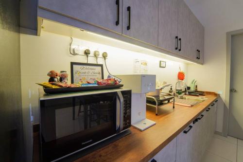 a kitchen with a microwave on a wooden counter at Horizon Ipoh 8Pax 3R2B - Tropical Bali Retreat in Ipoh