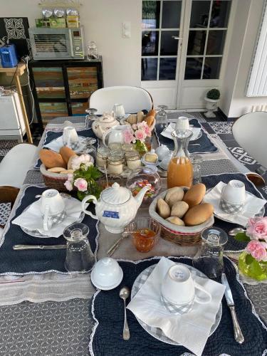 un tavolo con un servizio da tè con del cibo sopra di A la guiniere a Couëron