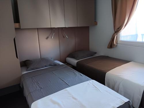 Habitación con 2 camas, armario y ventana en Mobilna kućica Mimi, en Sveti Petar
