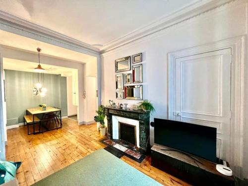 a living room with a fireplace and a table at Cosy Magnolia - T3 - Hyper centre & parking souterrain in Pau