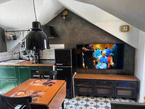a kitchen with a tv on the wall at Domus Lapidea in Postira