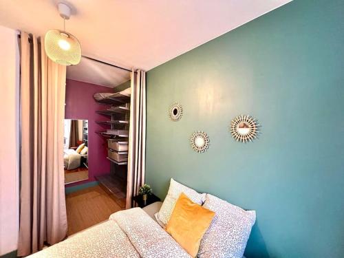 a living room with a couch and a blue wall at Cosy Magnolia - T3 - Hyper centre & parking souterrain in Pau