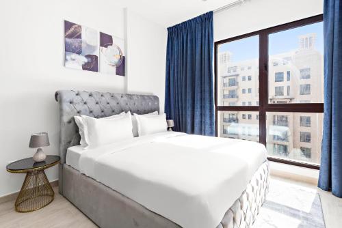 a bedroom with a large bed and a window at A Living One 1BR Apartment At Asayel 3, Madinat Jumeirah in Dubai