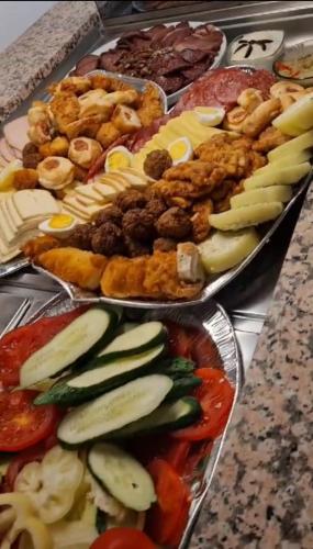 Pensiunea Kyfana Zarnesti في زارنيشتي: صواني مختلفة الأنواع من الطعام على طاولة
