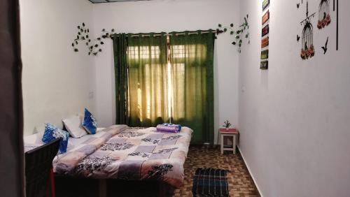 Un dormitorio con una cama frente a una ventana. en Vivek Home Stay, Bir Colony Chaugan, en Bīr