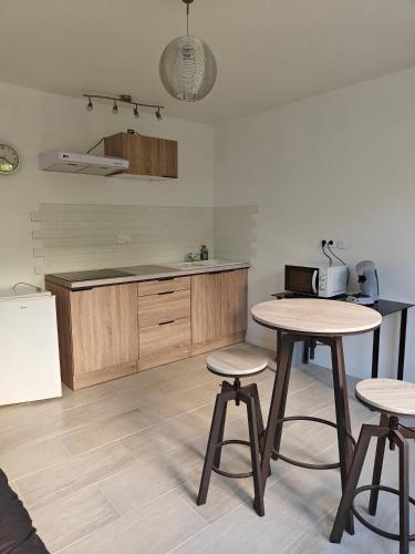 - une cuisine avec deux tables et deux tabourets dans l'établissement Studio équipé - Parking, à Saint-Gaudens
