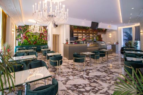 a restaurant with green chairs and a bar at Hotel Ambasada QTA in Patza-Kuqani