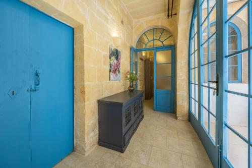 a hallway with a blue door and a stone wall at Room 5 - Twin Room x 2 by Solea in Għarb