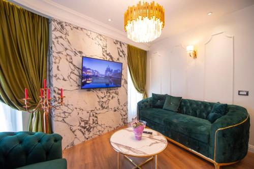 a living room with a green couch and a table at Hotel Ambasada QTA in Patza-Kuqani