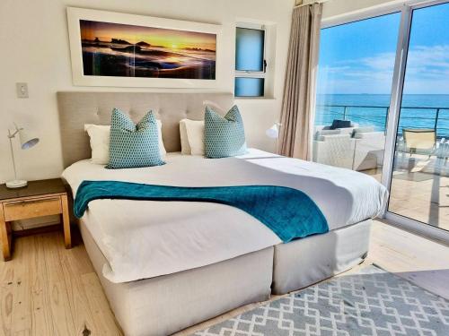 Un dormitorio con una cama grande con vista al mar. en Cosy Beach Bungalow On Clifton, en Ciudad del Cabo