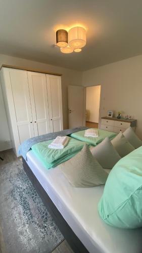 a bedroom with a large bed with green sheets at App1- SD11 Hindenburg in Friedrichskoog