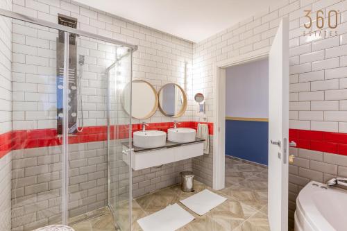 a bathroom with two sinks and two mirrors at Stunning 3BR APT with 2 Private Terraces in B'kara by 360 Estates in Birkirkara