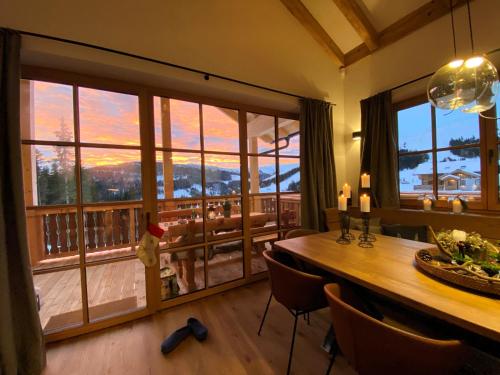 a dining room with a table and a large window at Sonnberg Chalet - Entspannung pur im Luxus Chalet mit Whirlpool-Sauna in Lachtal
