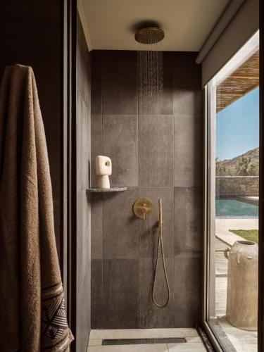 a bathroom with a shower with a glass door at The Royal Blue Resort & Spa Crete in Panormos Rethymno